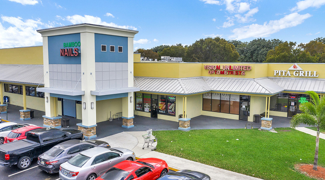 Higate Square retail plaza exterior with store signs and customer parking lot